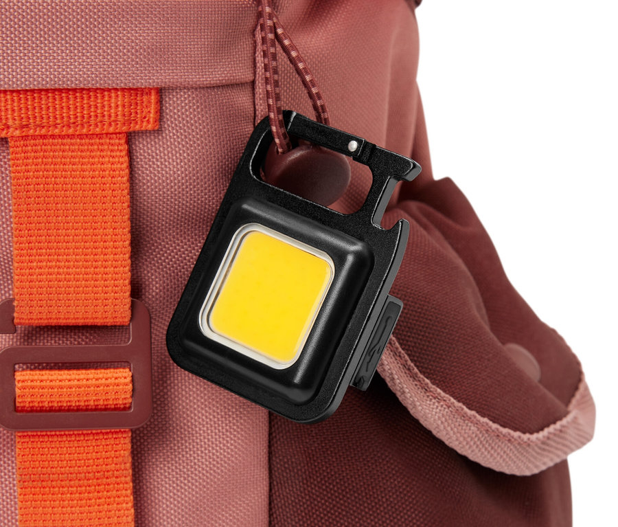 Multifunkční světlo visí na batohu.