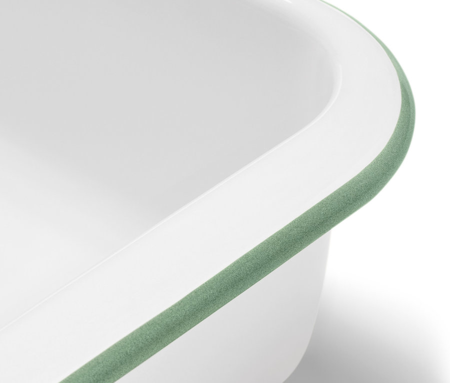 Detail bílé smaltované zapékací formy s víkem a zeleným lemem.