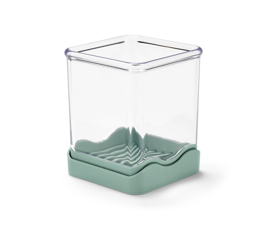 Průhledný kráječ na ovoce a zeleninu s podstavcem světle zelené barvy.