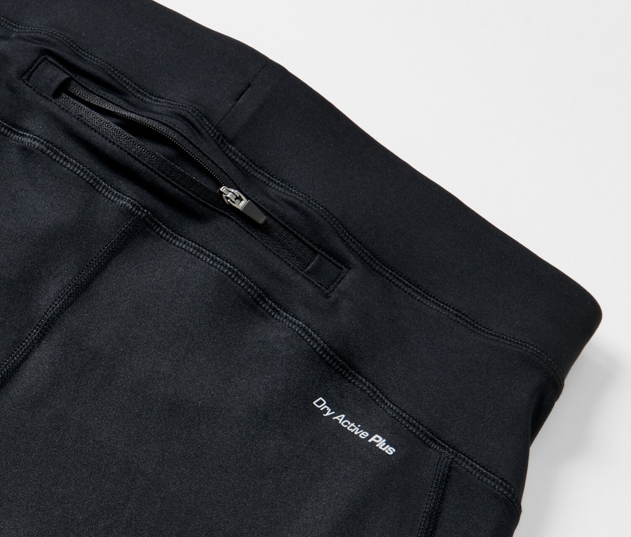 Detail černé běžecké legíny s kapsou na zip a nápisem Dry Active Plus.