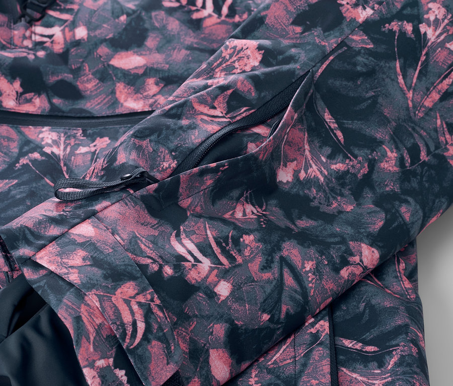 Detail lyžařské bundy s polovičním zipem a celoplošným potiskem.