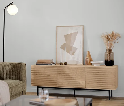 Hnědošedá manšestrová pohovka pro 3 osoby, černá stojací lampa se skleněnou koulí, nízká komoda »Finnsbo« a 2 konferenční stolky v obývacím pokoji.