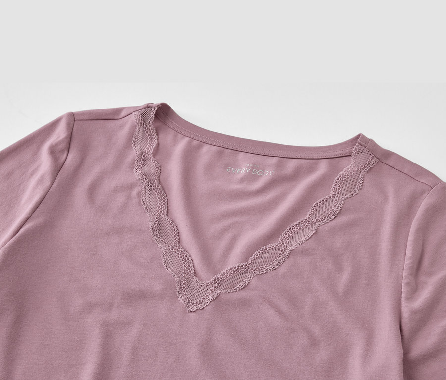 Detail fialového trička s krajkou ve výstřihu do V.