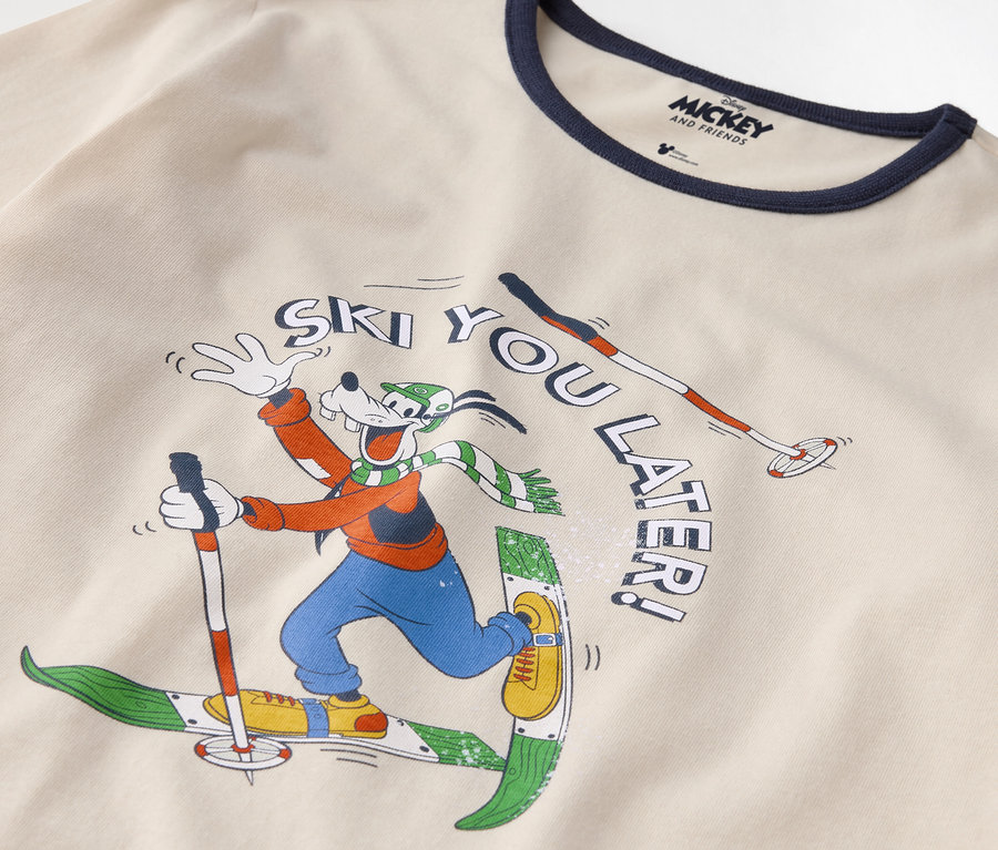Detail bavlněného trička s potiskem Goofyho na lyžích a nápisem "Ski you later!".