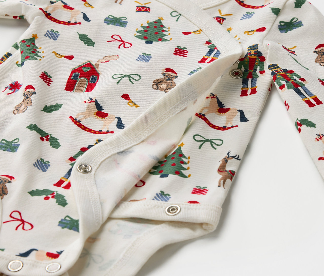 Detail bavlněného body s vánočním potiskem, zapínání na patentky.