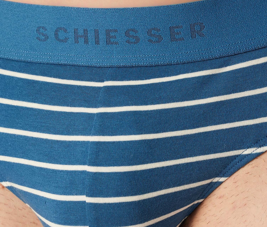 Detail pánských slipů Schiesser modré barvy s bílými vodorovnými pruhy.