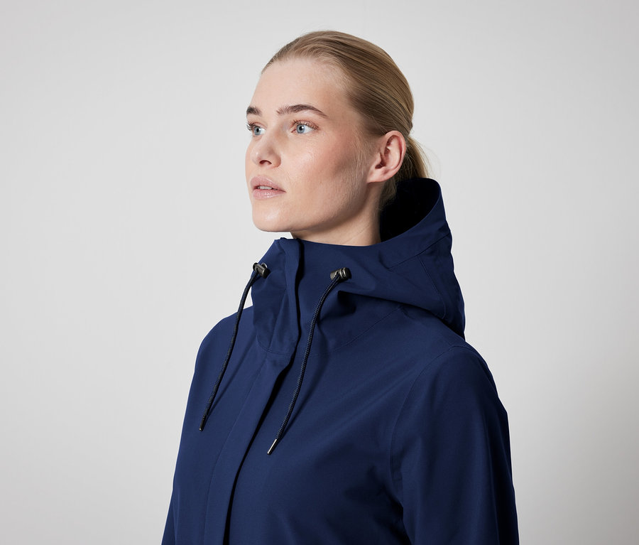 Žena má na sobě tmavě modrou bundu s kapucí.