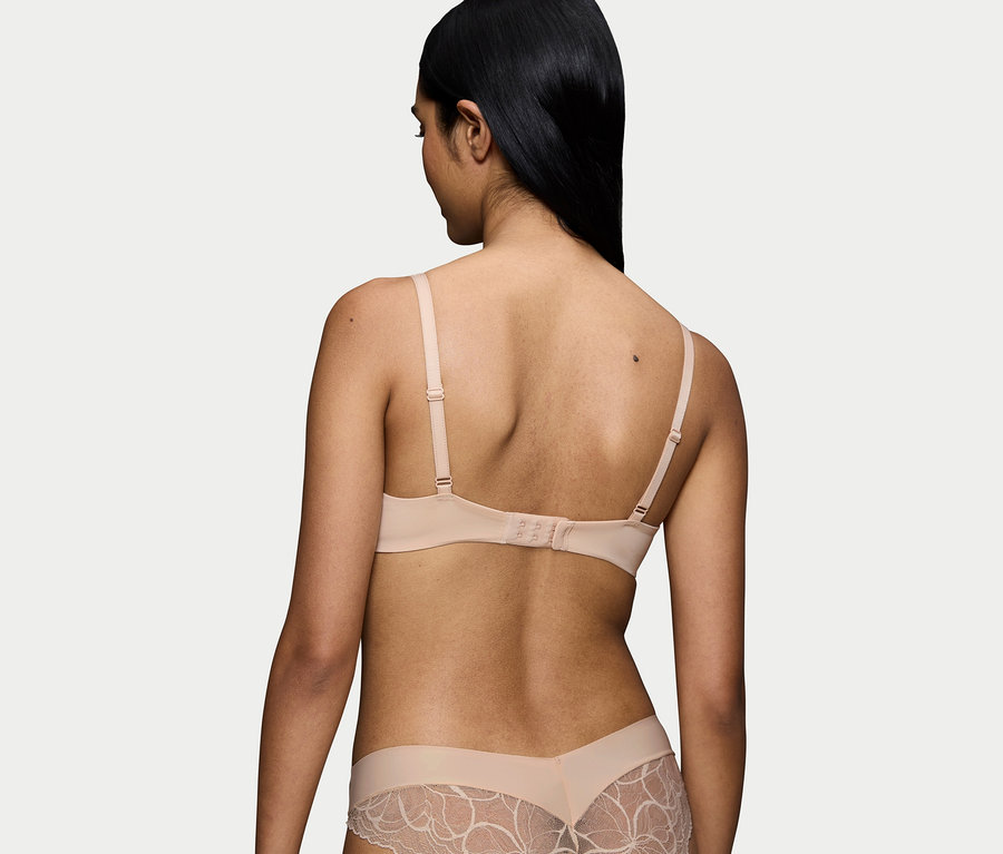 Pohled zezadu na ženu s černými vlasy v tělové podprsence a kalhotkách s krajkou.