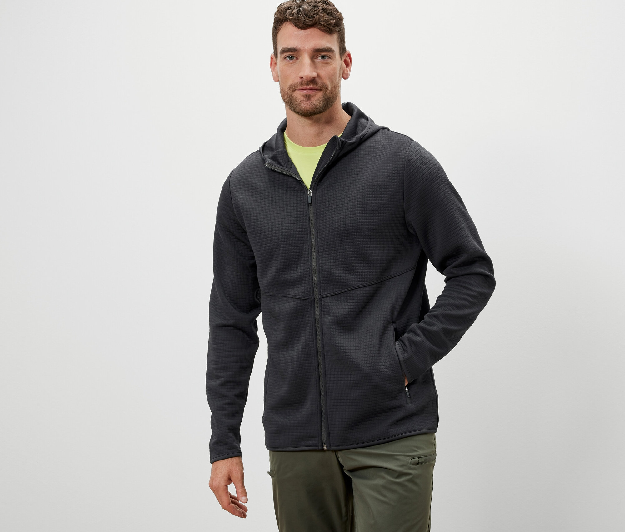 Muž má na sobě antracitovou funkční bundu.