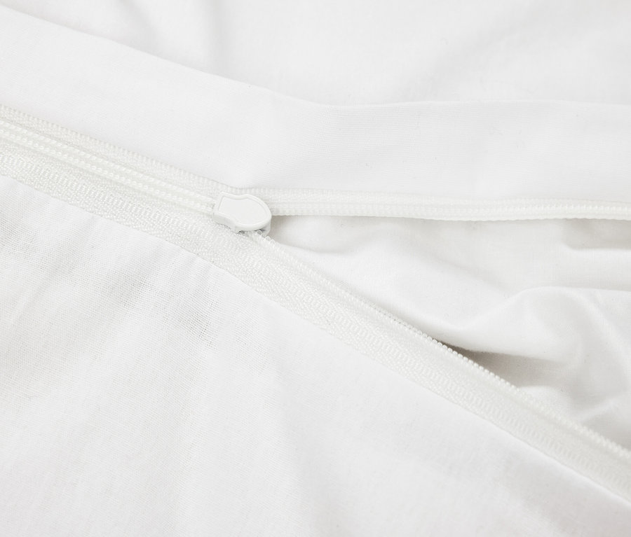 Detailní záběr na bílý látkový obal s bílým zipem.