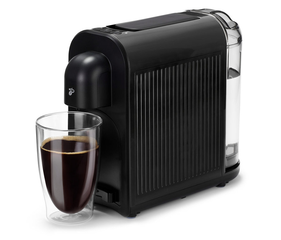 Černý kávovar Cafissimo now black vedle sklenice s kávou.