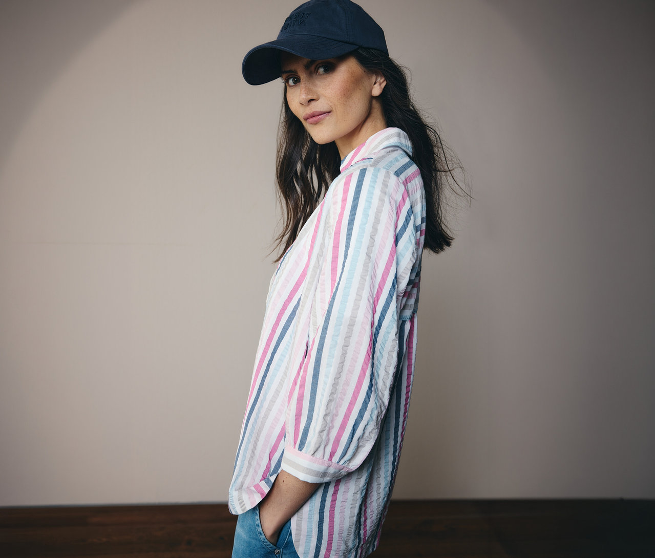 Žena v modré čepici a pruhovaná košilová halenka CECIL se dívá do kamery.