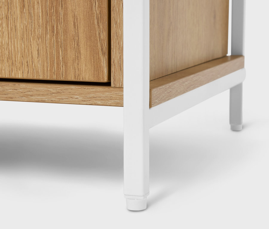 Detailní pohled na dřevěnou skříňku s bílým kovovým rámem.