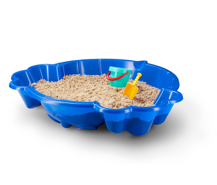 Modrá plastová skořápka pískoviště s pískem, zelený kbelík a žlutá lopatka.