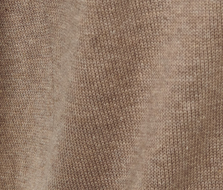 Detail hnědé pletené mikiny s kapucí.