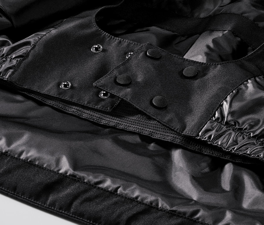 Detail černé lyžařské bundy.