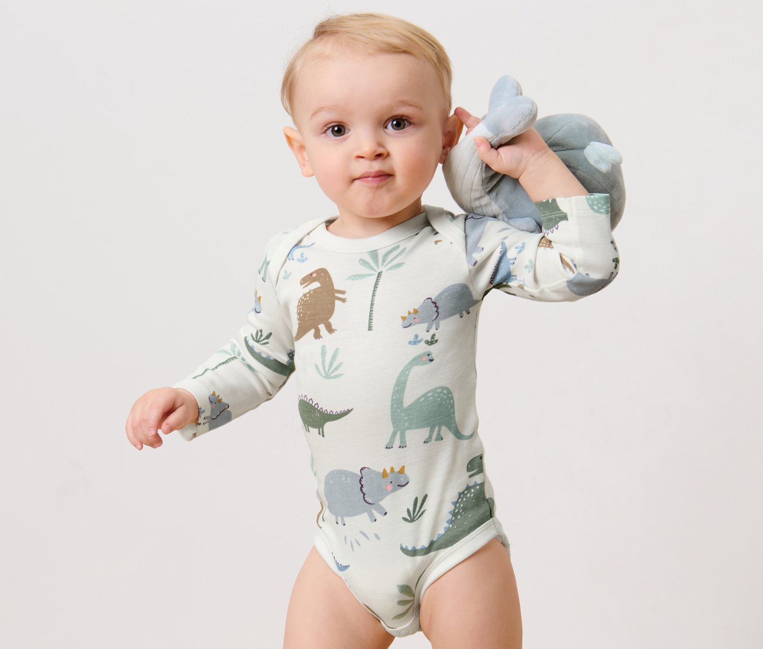 Dítě drží plyšovou hračku a má na sobě body s dlouhým rukávem, 3 ks, dinosauři.