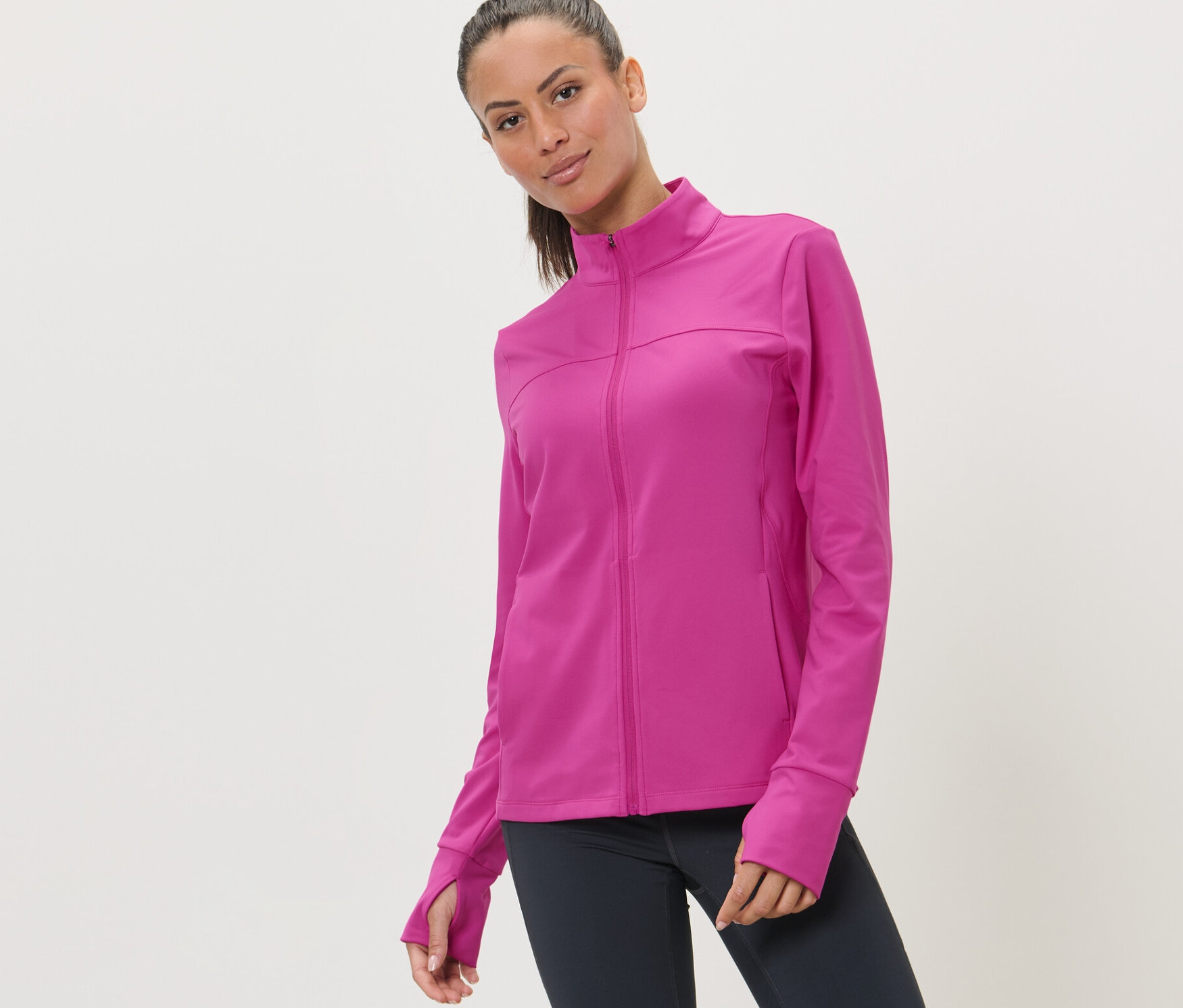 Žena má na sobě růžovou sportovní bundu.