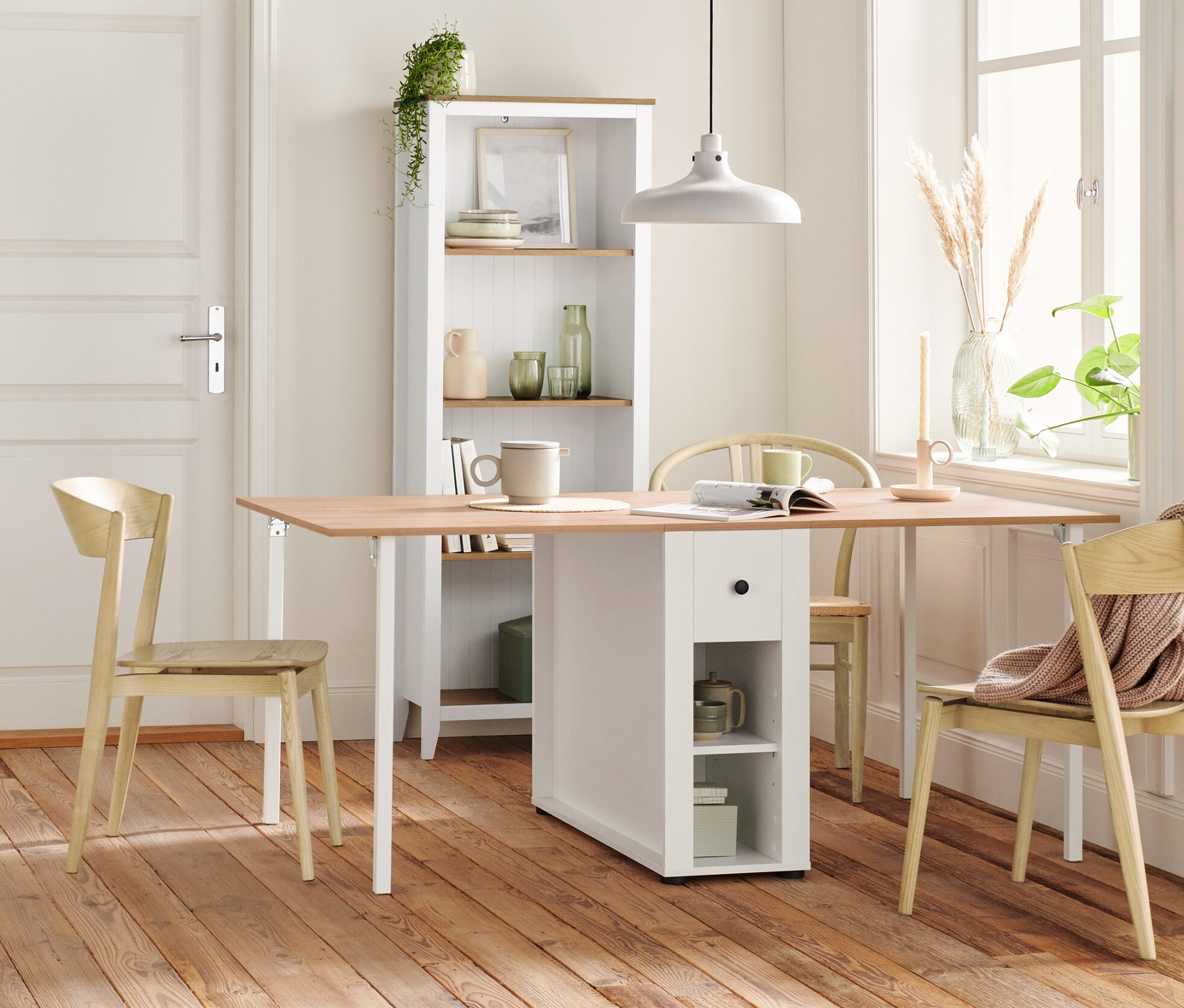 Interiér s dřevěnou podlahou, dřevěnou židlí, regálem, příborníkem se zásuvkami a stolní lampou s dřevěným podstavcem.