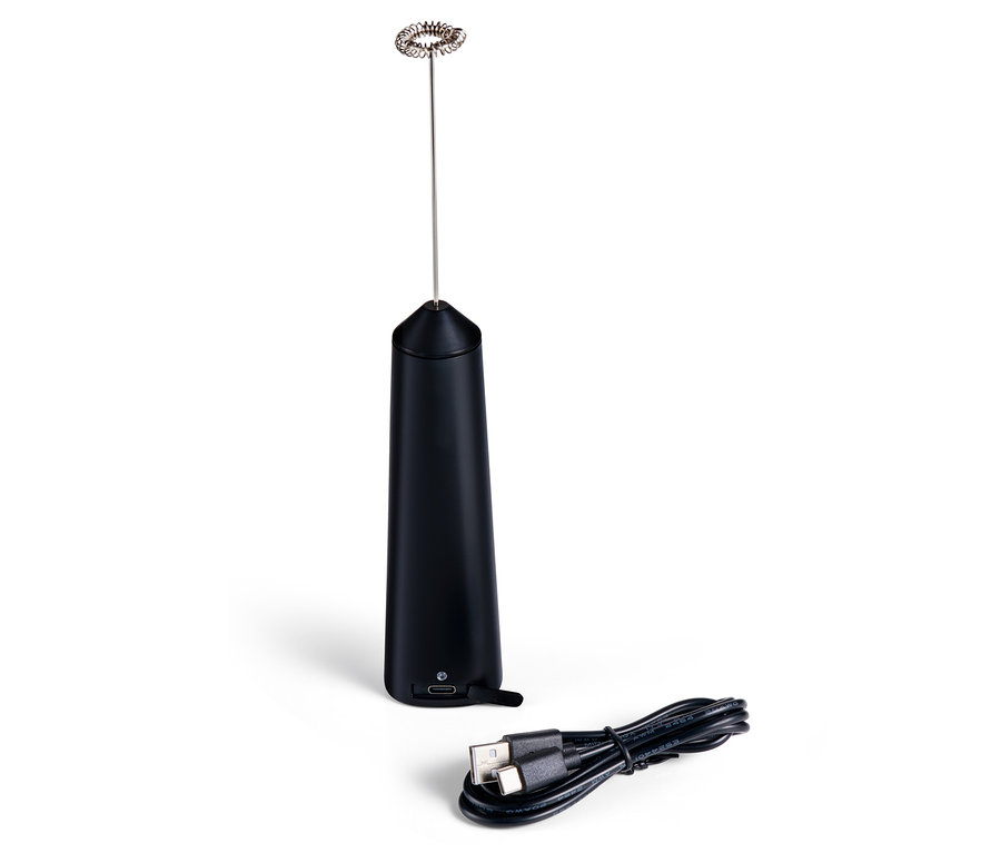 Černý dobíjecí napěňovač mléka a nabíjecí kabel leží na bílém povrchu.