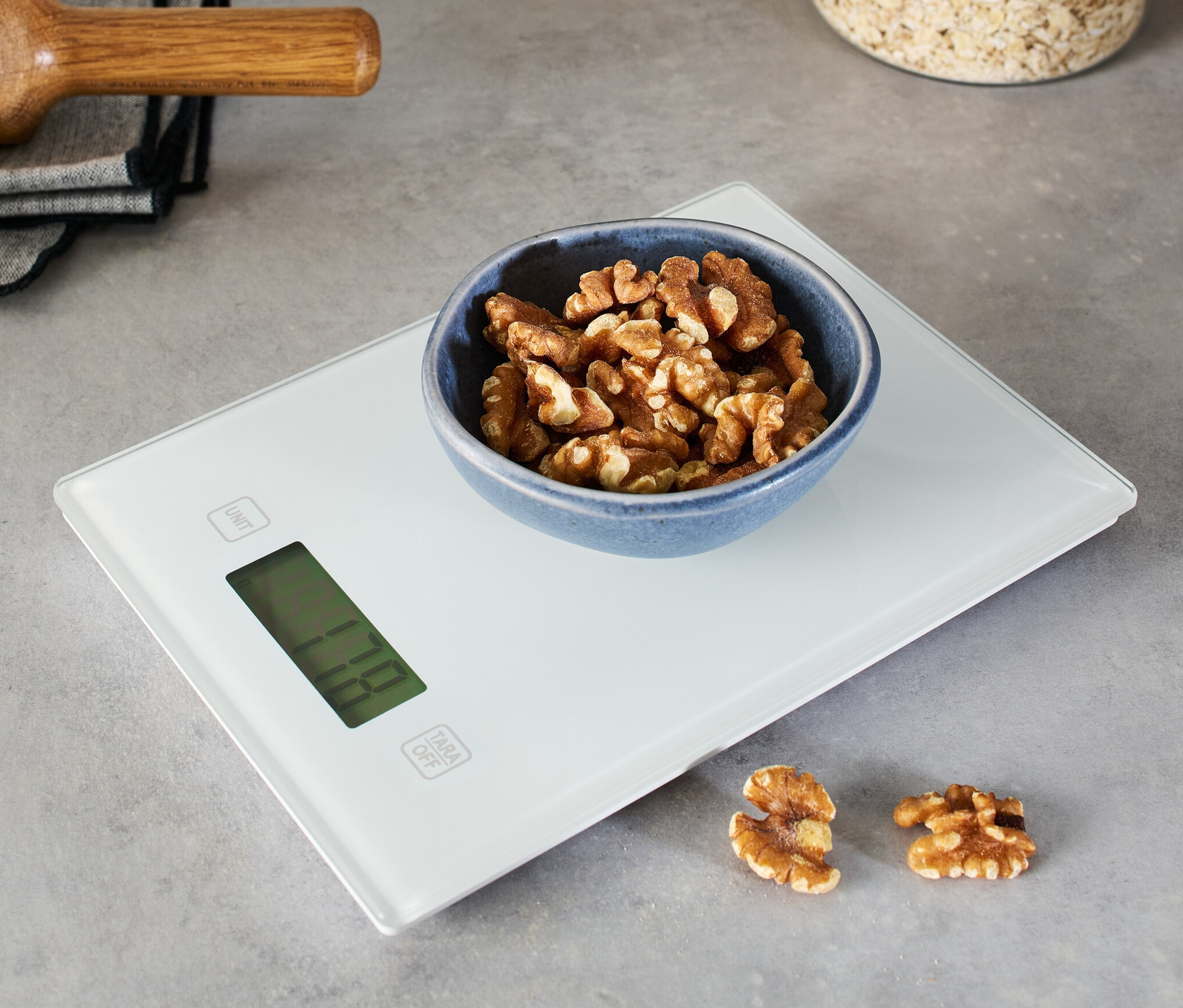 Miska vlašských ořechů na digitální kuchyňské váze.