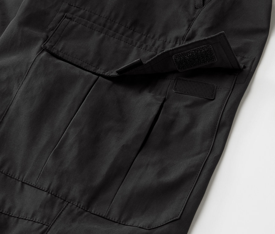 Detail černých outdoorových kalhot s kapsou s ochranou proti komárům.