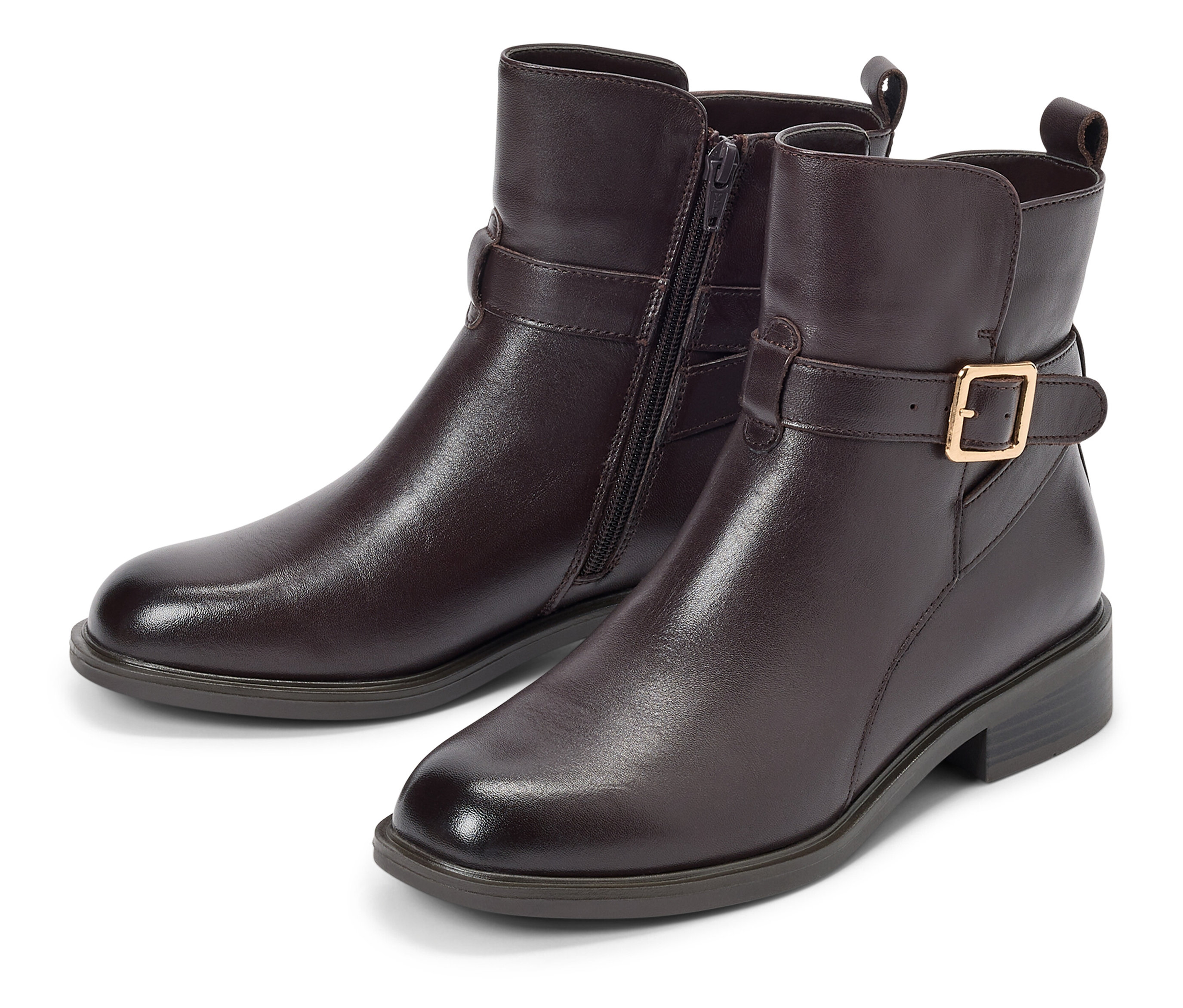 Dva hnědé kotníkové boty s přezkou a zipem leží na bílém pozadí.