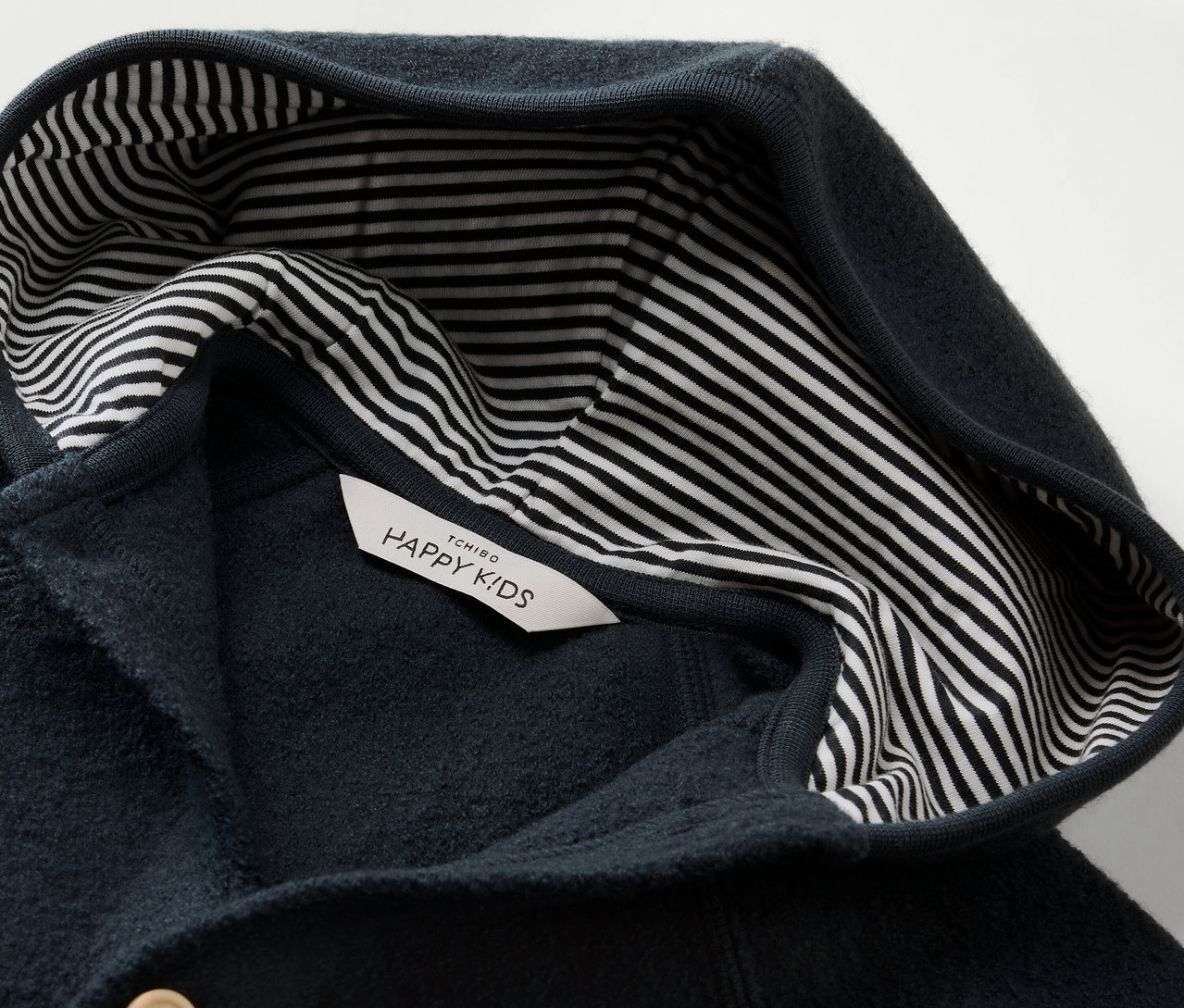 Detail modrého dětského overalu Vycházkový overal pro miminka s vlnou merino s kapucí a pruhovanou podšívkou.