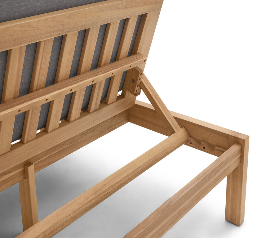 Detailní pohled na dřevěné zahradní lehátko s šedým čalouněním.
