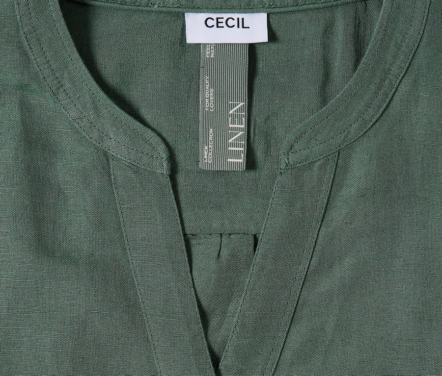 Detail zelené lněné košile Cecil s výstřihem do V a štítkem.