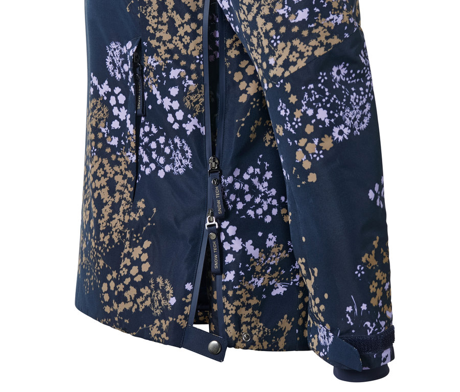 Detail lyžařské bundy s krátkým zipem s květinovým vzorem.