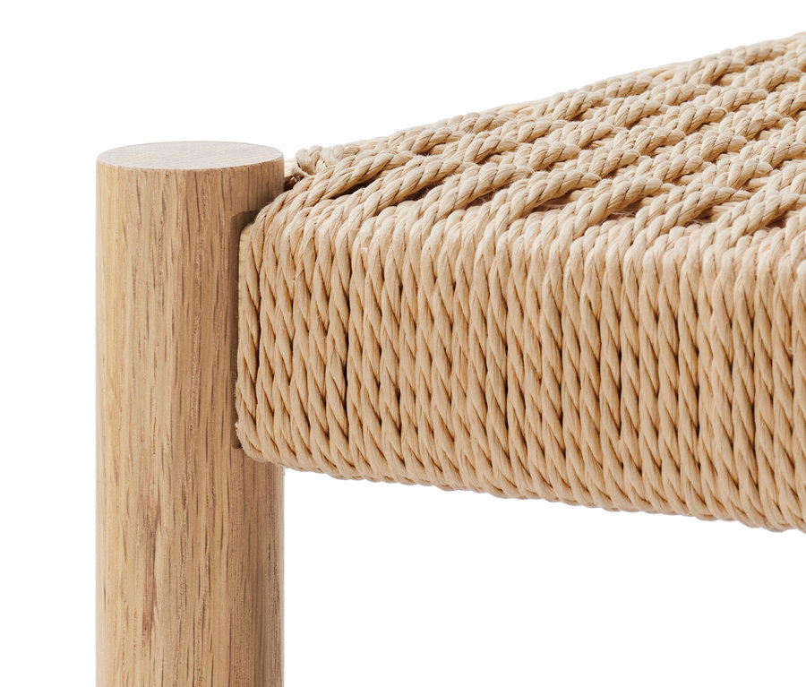 Detail dřevěné lavice s pleteným sedákem.