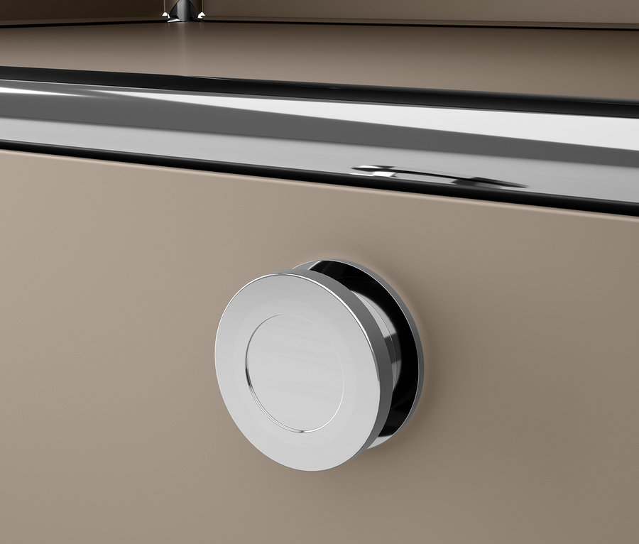 Detail šedobéžové kovové komody CN3 s chromovanou kulatou rukojetí.