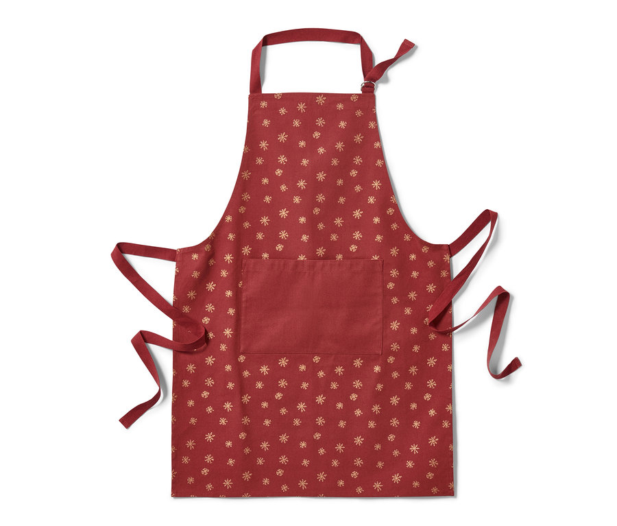 Červená kuchyňská zástěra s motivem sněhových vloček.
