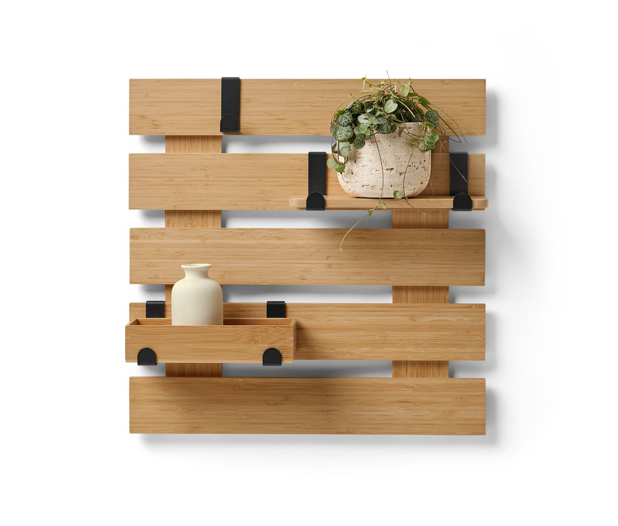 Nástěnný regál s flexibilními háčky a policí, na kterém je váza a květináč.