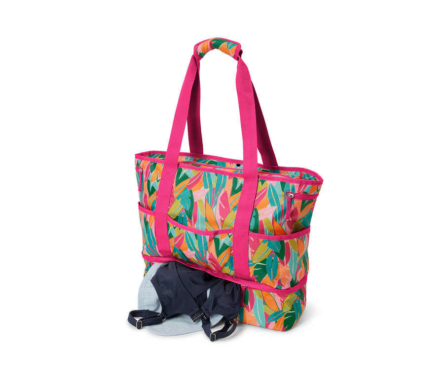 Plážová taška s celoplošným potiskem. V tašce je modrá podprsenka.