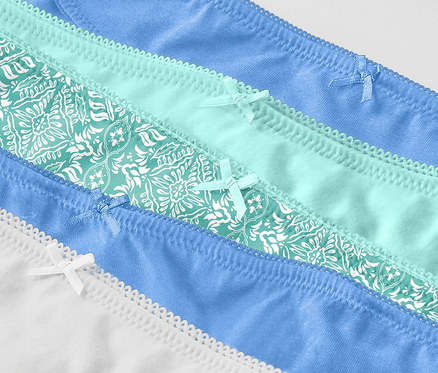 Detail záběru pěti párů kalhotek různých barev.