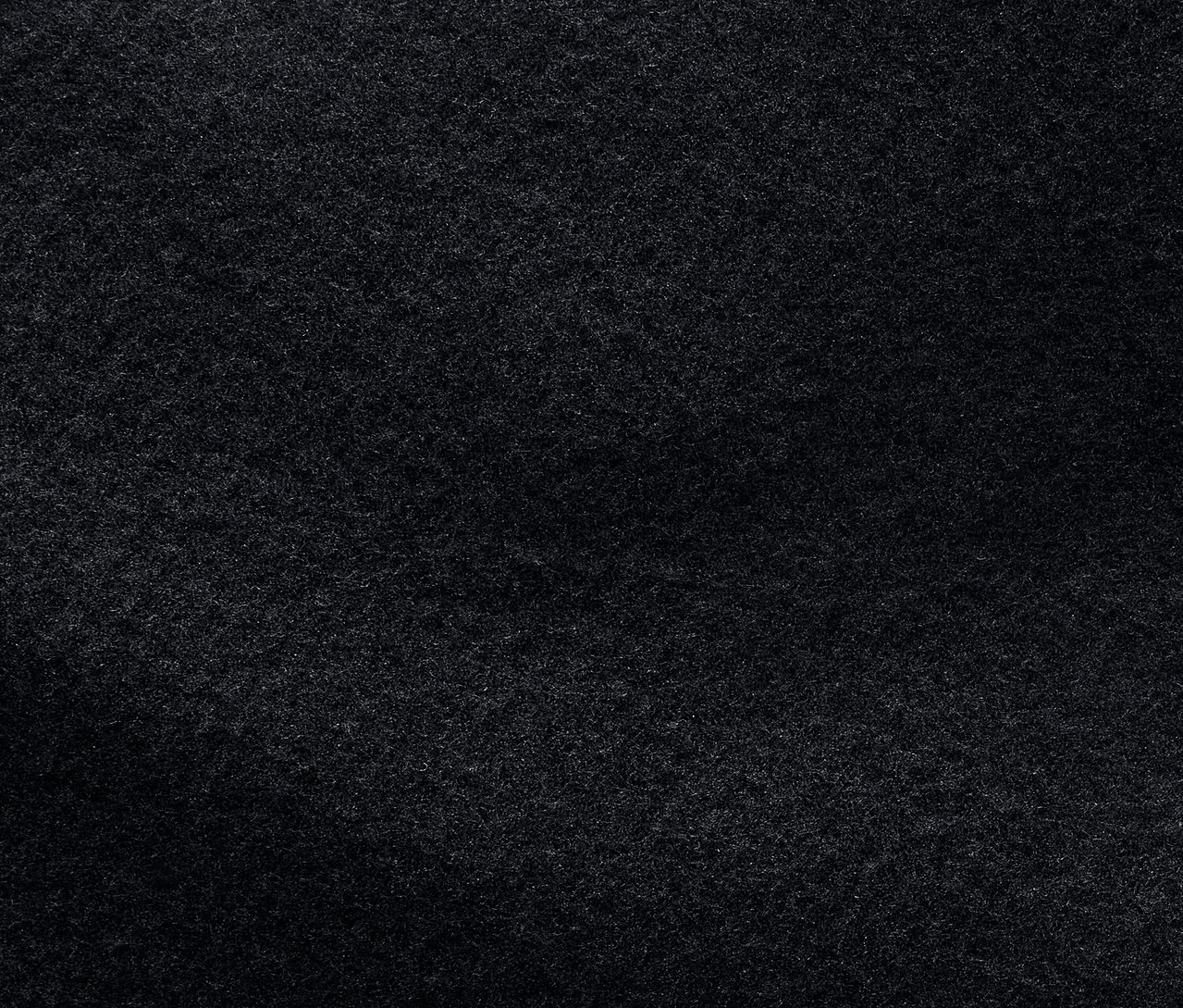 Detailní záběr na texturu tmavě šedé látky.