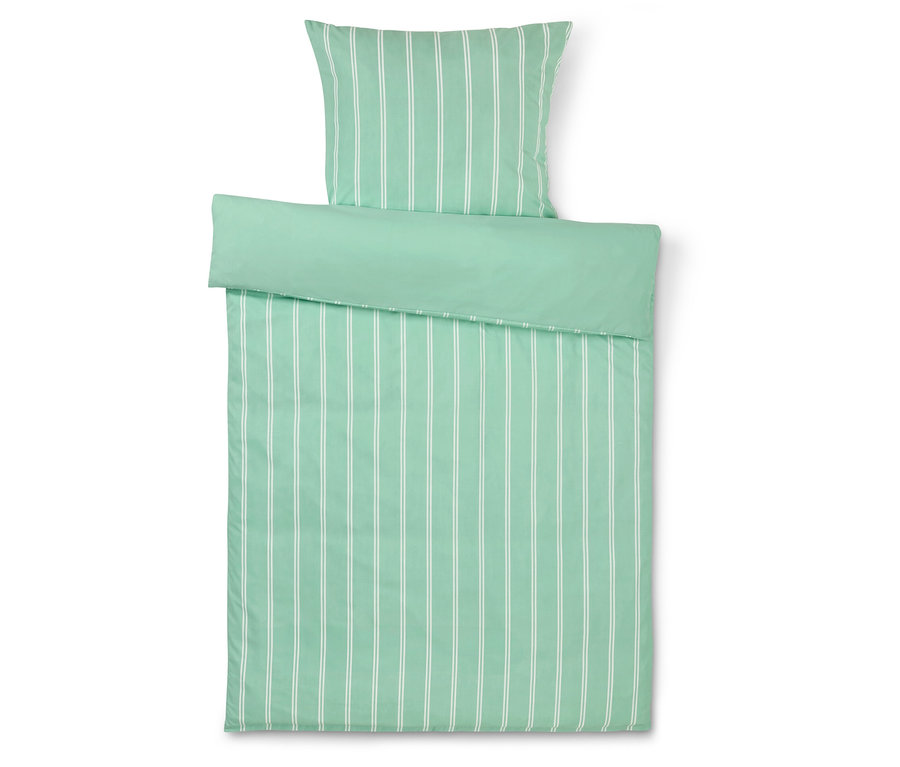 Pohled shora na ložní soupravu s povlakem na polštář a přikrývku svislými bílými pruhy na zeleném pozadí.