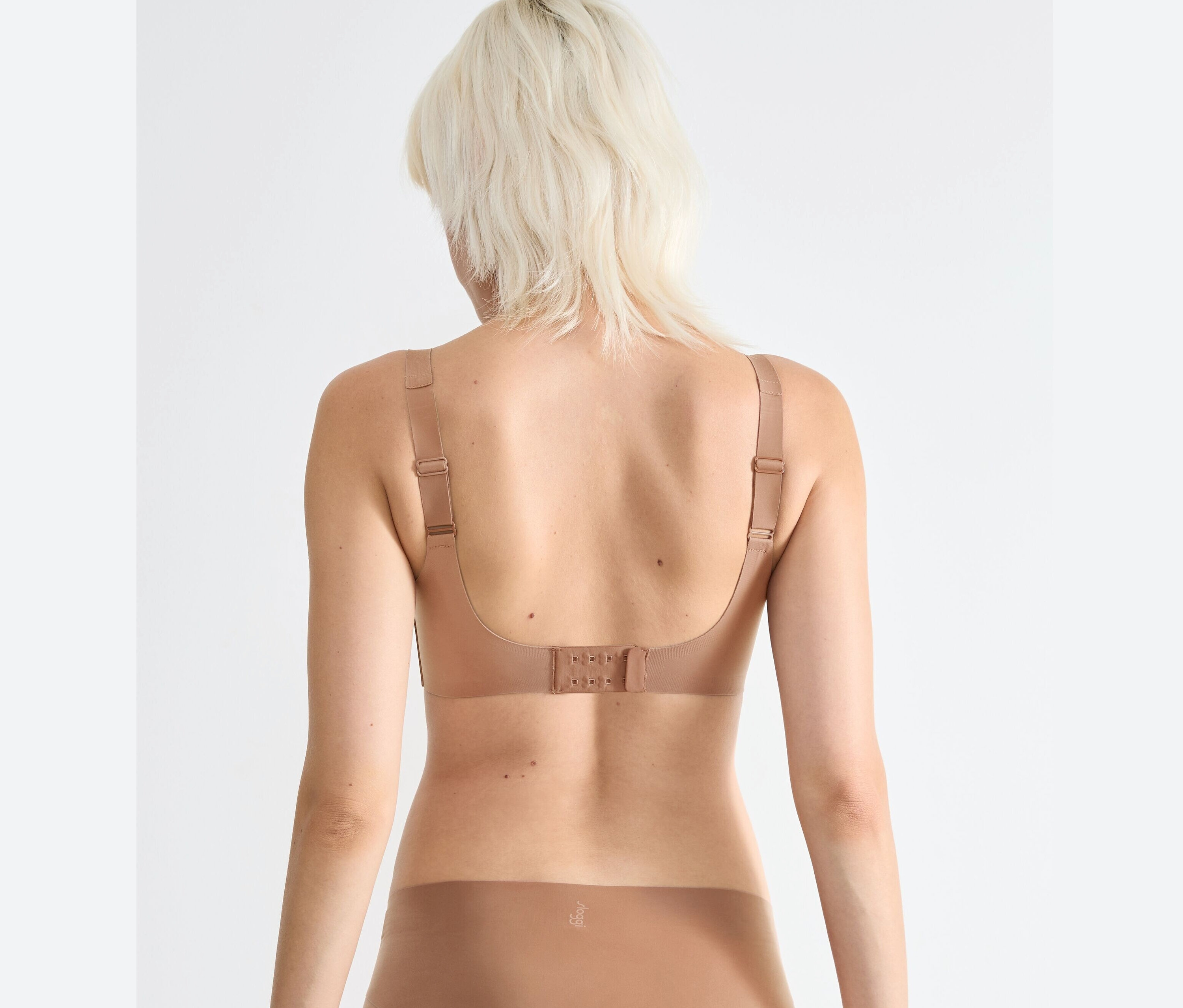 Zezadu žena nosí hnědou podprsenku sloggi ZERO Feel 2.0 Soft Bra.