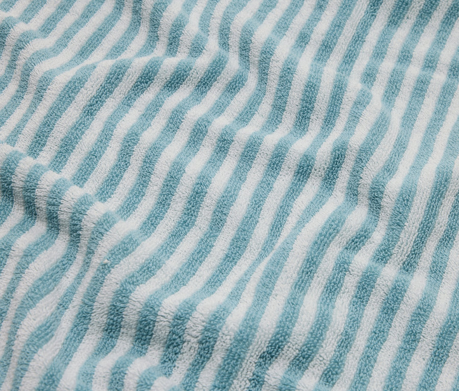 Detailní záběr na modro-bílý pruhovaný froté ručník.