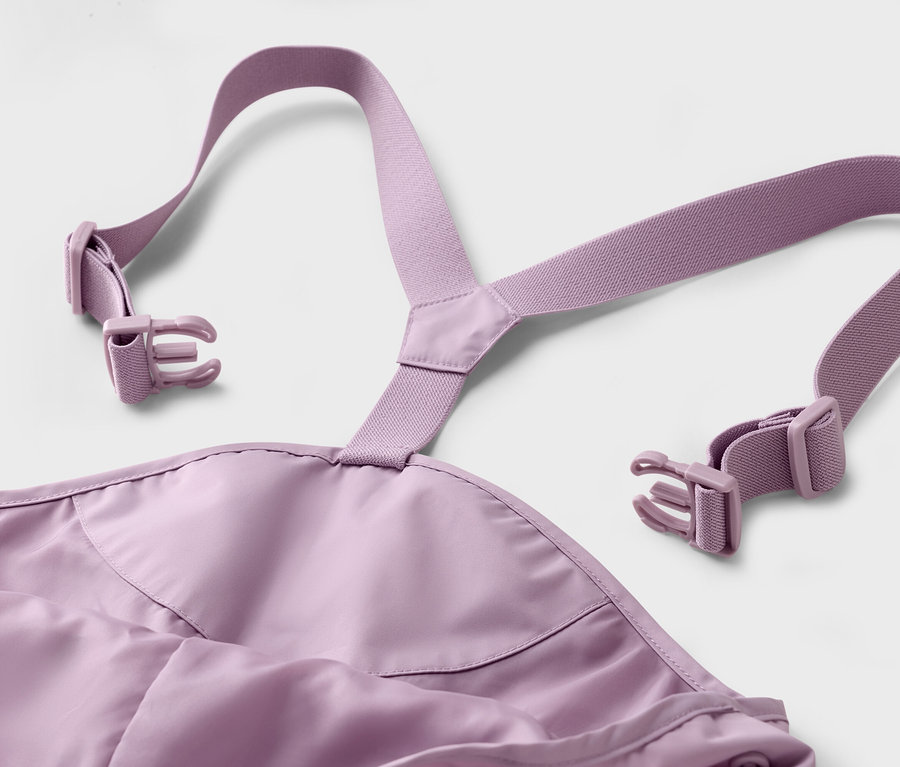 Detail fialových ramínek a přezek na bílém pozadí.