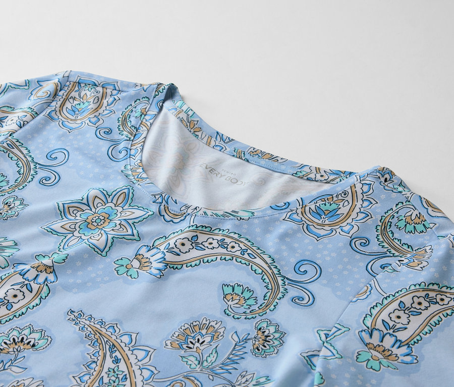 Detailní záběr světle modrého topu se světle modrým paisley vzorem.