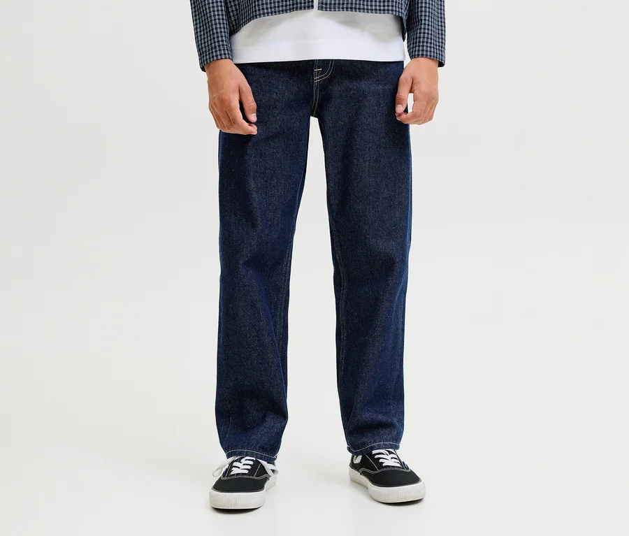 Osoba má na sobě tmavě modré džíny Jack & Jones JJOriginal Chris, bílé tričko, modrobílou kostkovanou bundu a černé tenisky.