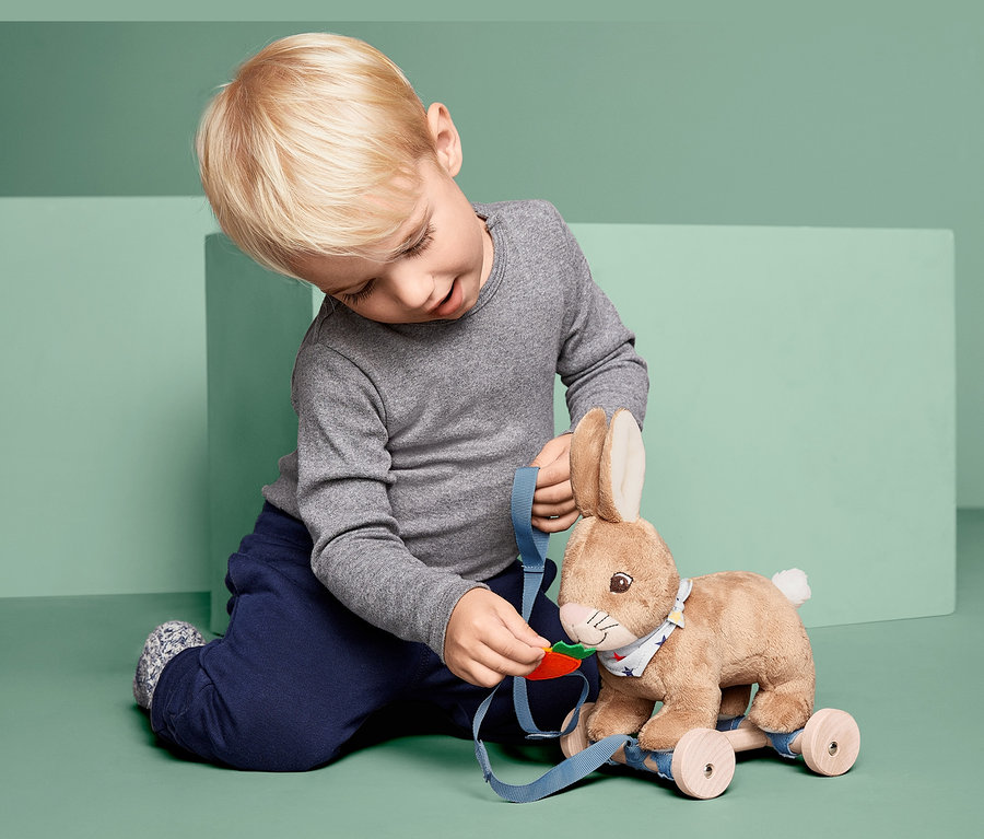 Chlapec si hraje s tahacím zajíčkem.
