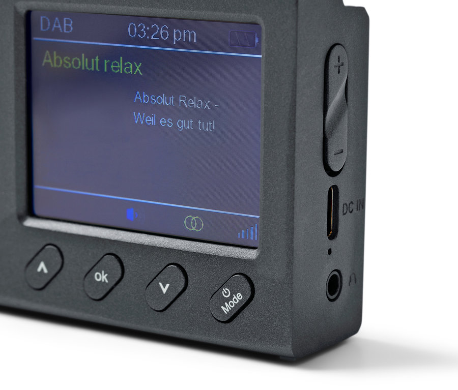 Detailní pohled na černé přenosné rádio DAB/FM s Bluetooth, které zobrazuje "Absolut relax" na obrazovce.