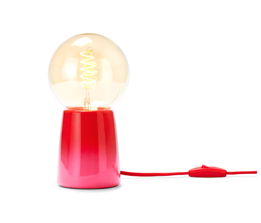 Červená stolní LED lampa se žárovkou.