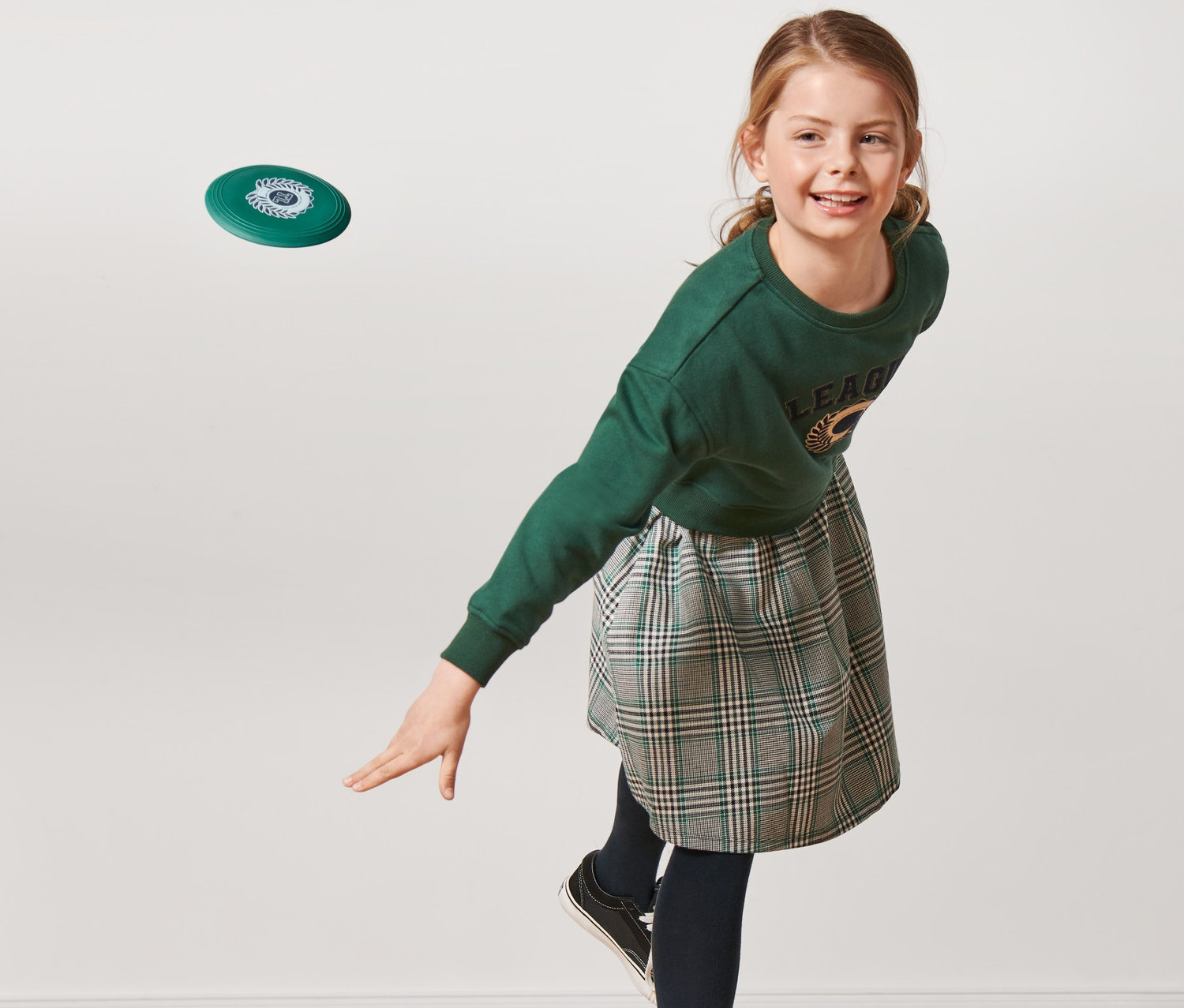 Dívka hází létající talíř.