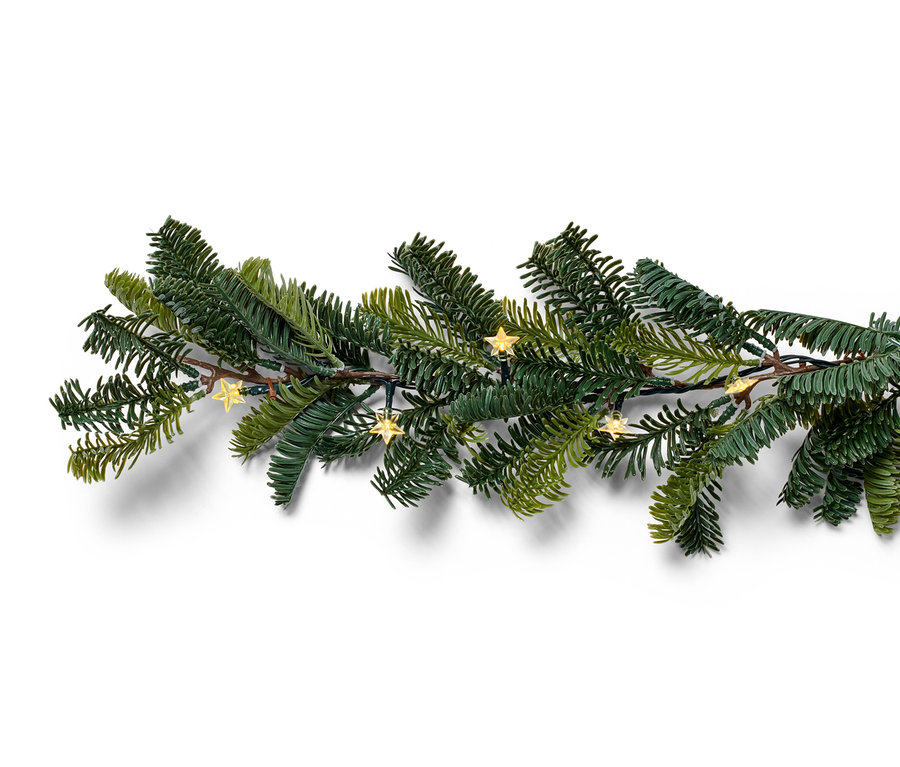 Detailní záběr na jedlovou girlandu s LED světýlky ve tvaru hvězdy na bílém pozadí.