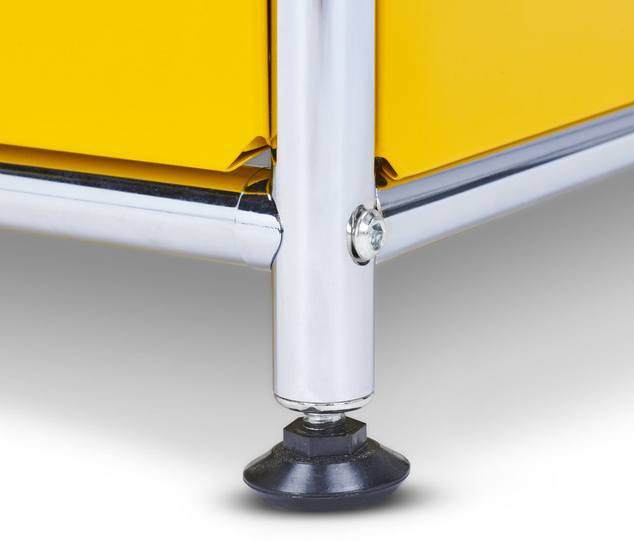 Detail žluté kovové skříňky CN3 s chromovanou nohou.